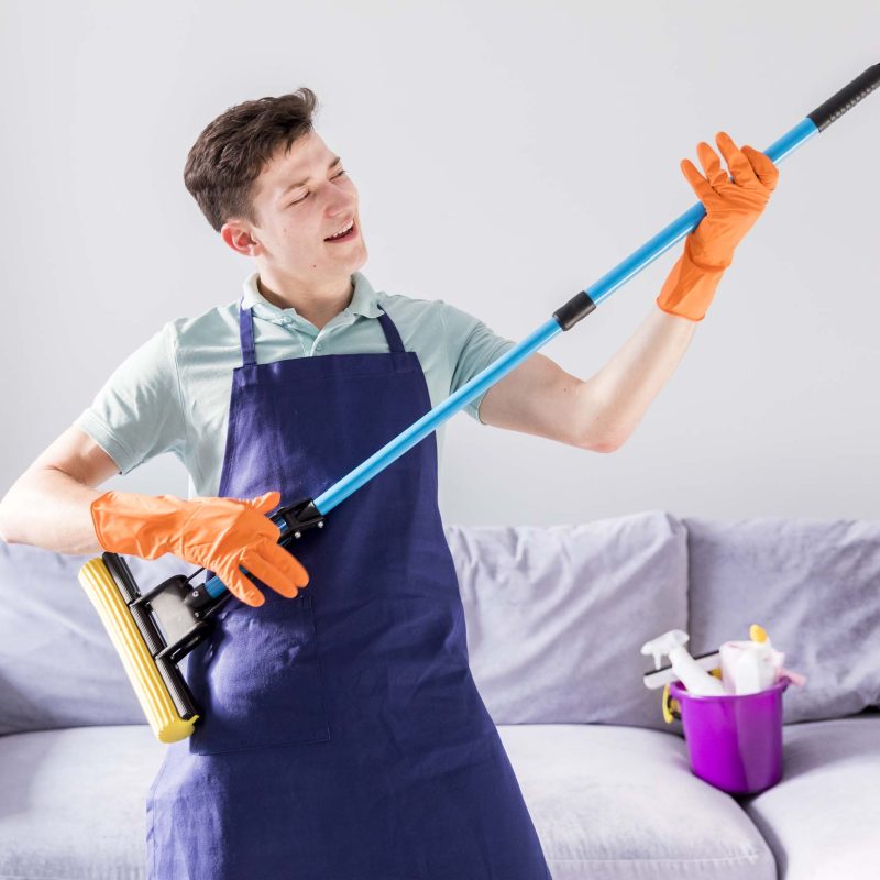 Man holding mop before Air BNB rental cleaning